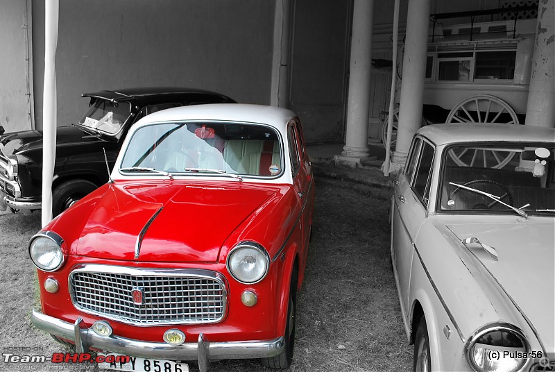 Indian visitors look at vintage cars parked at the UB City Mall